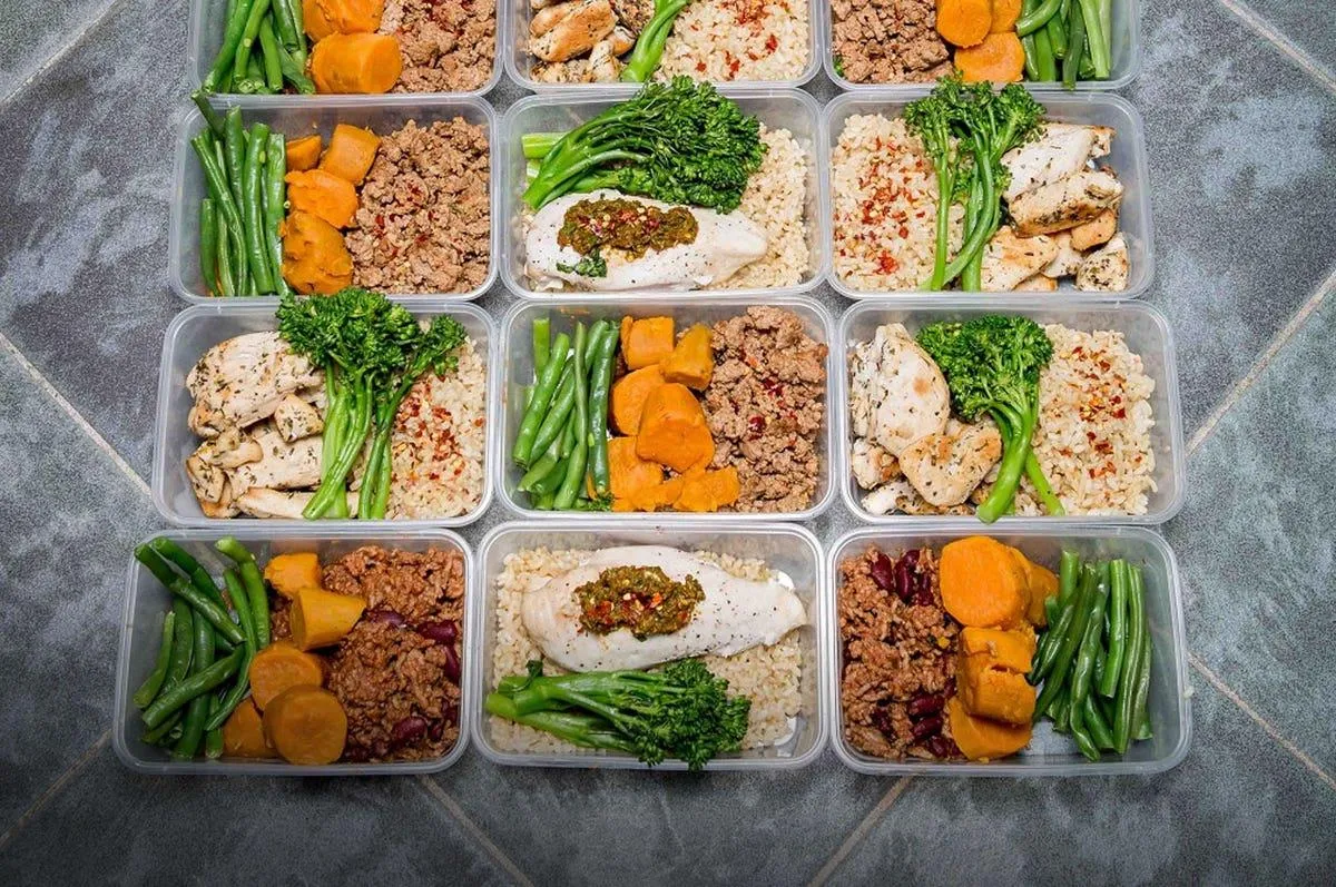 A bright fitness-focused nutrition scene featuring balanced whole-food meals with lean protein, colorful vegetables, complex carbohydrates, and healthy fats. The imagery emphasizes fueling the body for performance, recovery, and long-term health rather than restrictive dieting.